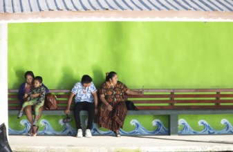 Guatemalans wait at the boat dock in Livingston on the Rio Dulce River, Izabal Department,