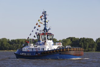 Decorated ship type Fairplay-91 tugboat leaves the port of Hamburg on the Elbe after Hamburg's port