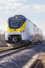 Modern railway runs on rails through rural areas under blue skies, fire brigade exercise at the