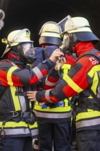 Firefighters wearing respirators and protective clothing prepare in the tunnel, fire brigade