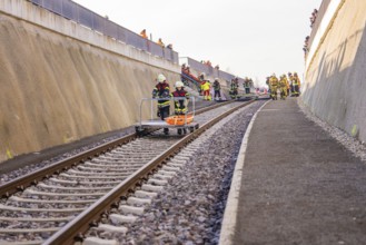 Firefighters work on the rails in a steep area surrounded by sandy walls, fire brigade exercise on