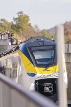 A train runs along the edge at an elevated point with spectators, fire department exercise at the