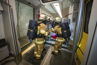 Firefighters board a train with special equipment in a rescue operation, fire brigade exercise on