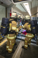 Firefighters wearing brown equipment during a rescue operation on the train, fire brigade exercise