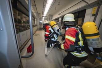 Two firefighters are working on a safety incident inside a train, fire brigade exercise on the