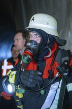 Close-up of a firefighter wearing respiratory mask and protective clothing in a tunnel, fire
