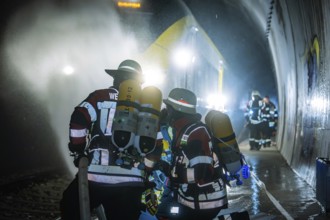 Firefighters working in a gloomy tunnel with respirators, fire brigade exercise on the Hermann