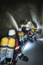 Several firefighters in a tunnel filled with a train, fire brigade exercise on the Hermann Hesse
