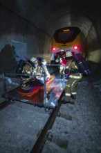 Firefighters carry out a rescue on rails in a tunnel, fire brigade exercise on the Hermann Hesse