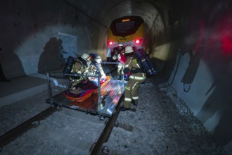 Firefighters work in an illuminated tunnel during a rescue operation, fire brigade exercise on the