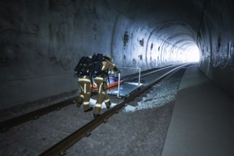 Two firefighters push a stretcher through a dark tunnel, fire brigade exercise on the Hermann Hesse