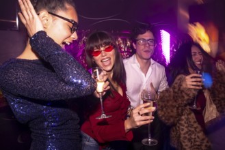 Group of diverse friends celebrating a special occasion, drinking champagne, dancing and having fun