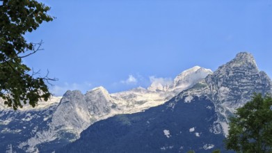 Mountains under clear blue sky, rocky peak in foreground, Slovenia
