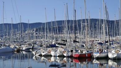 Lots of boats in a marina surrounded by mountains under clear blue skies, Slovenia