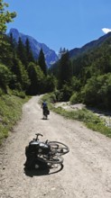 A bike is lying on a bike path surrounded by forests and mountains, Slovenia
