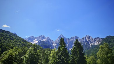 Mountain range with wooded foreground and blue sky, Slovenia