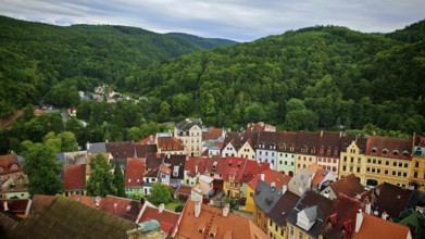 Panorama of a city with colorful roofs surrounded by wooded hills, view of Loket from above, Czech