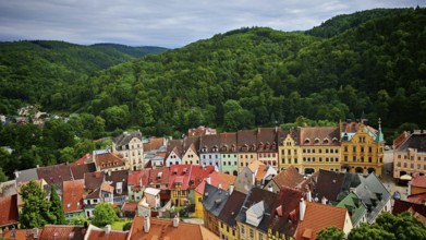 Historic town with colorful roofs surrounded by wooded hills, view of Loket, Czech Republic