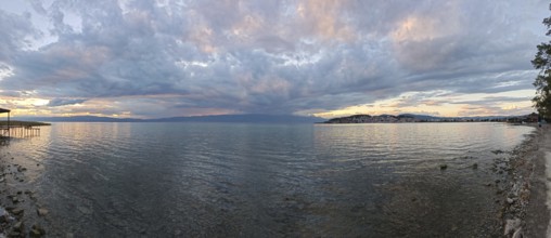 Panoramic view of a lake at sunset with dramatic clouds in the sky, Lake Ohrid, North Macedonia