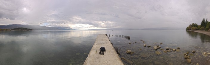 Panoramic picture of a long jetty over a wide, calm lake, Lake Ohrid, North Macedonia
