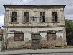 An old, dilapidated building with closed shutters and crumbling façade, Ohrid, North Macedonia