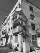 Wired old façade equipped with satellite dishes in the city, Albania