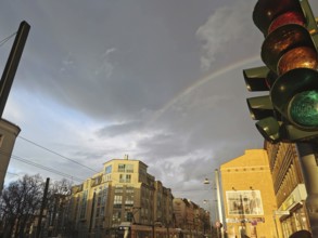 Rainbow over urban scene with traffic light and cloudy sky, Berlin