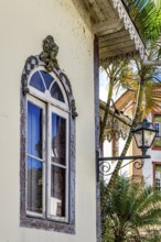 Old window decorated with a sculpture of a face and other ornaments in a historic house in the city