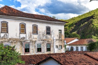 Facade of a historic colonial mansion deteriorated by time in the city of Ouro Preto in Minas