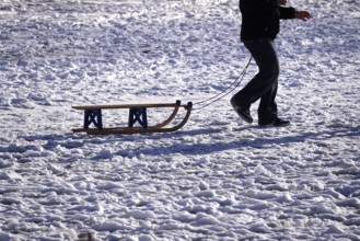 Sled in snow pulled by a man, winter, Germany
