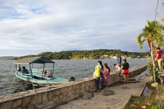Guatemalans and a boat on the shore, Lake Petén Itzá in Flores, Petén Department, Guatemala