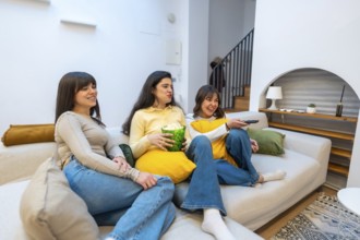 Group of happy young women friends relaxing on a comfortable couch at home, spending leisure time