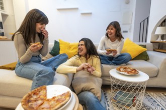 Three young women relaxing on a couch and floor, sharing pizza slices during a casual gathering,