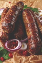 Fried kupaty on parchment, with red onion and pomegranate, kupaty, Georgian cuisine