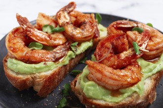 Sandwiches with avocado and caramelized shrimp, micro-greens, breakfast, on a plate, top view,