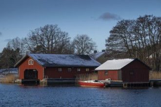 Falun-painted boathouses and motor boat, Korpoström, Korpo or Korppo, southwestern archipelago,