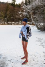 Man with cap, 55, standing on the ice wrapped in a towel after ice bathing, Thumsee, Bad