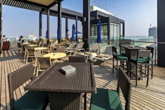 Cosy roof terrace with tables and chairs, city views, sunny ambiance