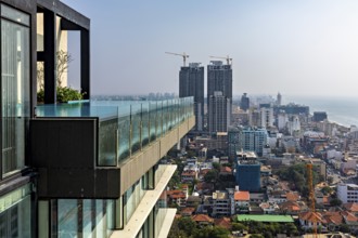 Urban view with modern high-rise buildings and a pool on the edge of a building with sea views