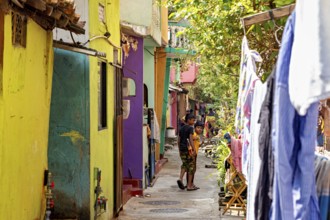 Colourful alley with children playing and hanging clothes, lively and warm