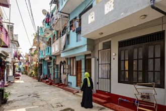 Urban street with colorful buildings and a woman in traditional clothes