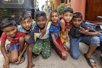Six children pose happily on the street in colorful clothes, showing joy