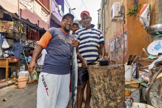 Friendly people pose at a busy street market surrounded by cooking supplies