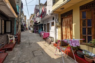 Sunny narrow street with residential buildings and clotheslines in an urban setting