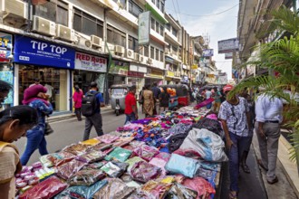Street market with laid-out clothes and busy foot traffic, the hustle and bustle of Colombo city