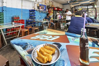 Casual snack with colorful tables and chairs, relaxed atmosphere, food and drinks on the tables,