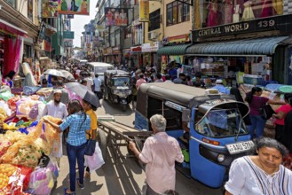 Busy street with market stalls, people and rickshaws in a busy shopping district, the hustle and