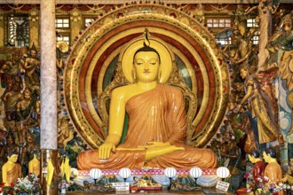Buddha statue in meditating posture surrounded by ornate gold decoration and spiritual symbols in