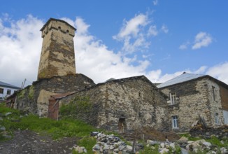 Old stone ruin with defence tower against a cloudy sky, defensive tower, Ushguli, Shibiani