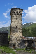 Old defensive defence tower against a backdrop of mountains and blue skies. Historical construction